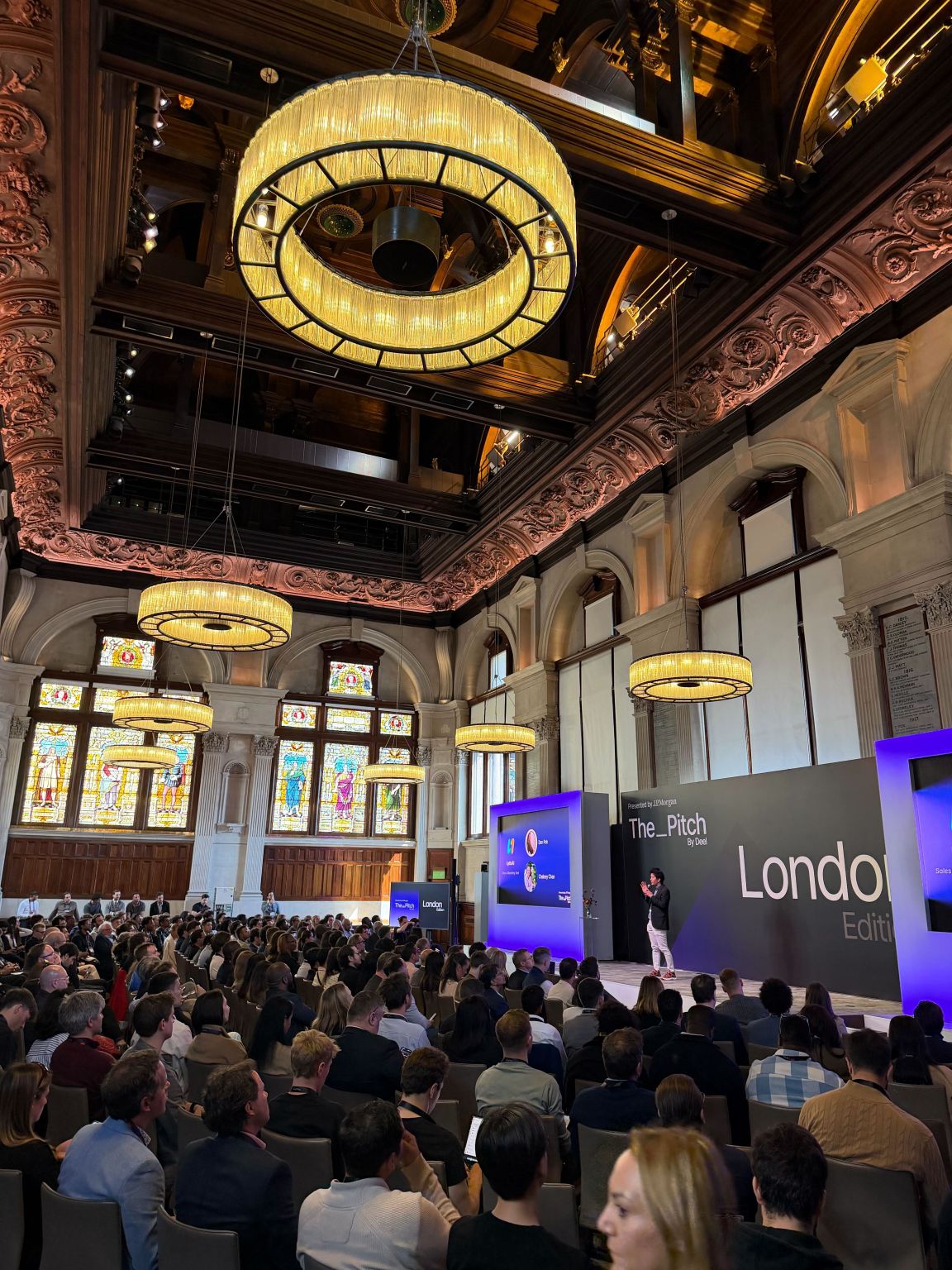 The Pitch London Edition in progress: a full audience in a grand historic hall facing the branded main stage